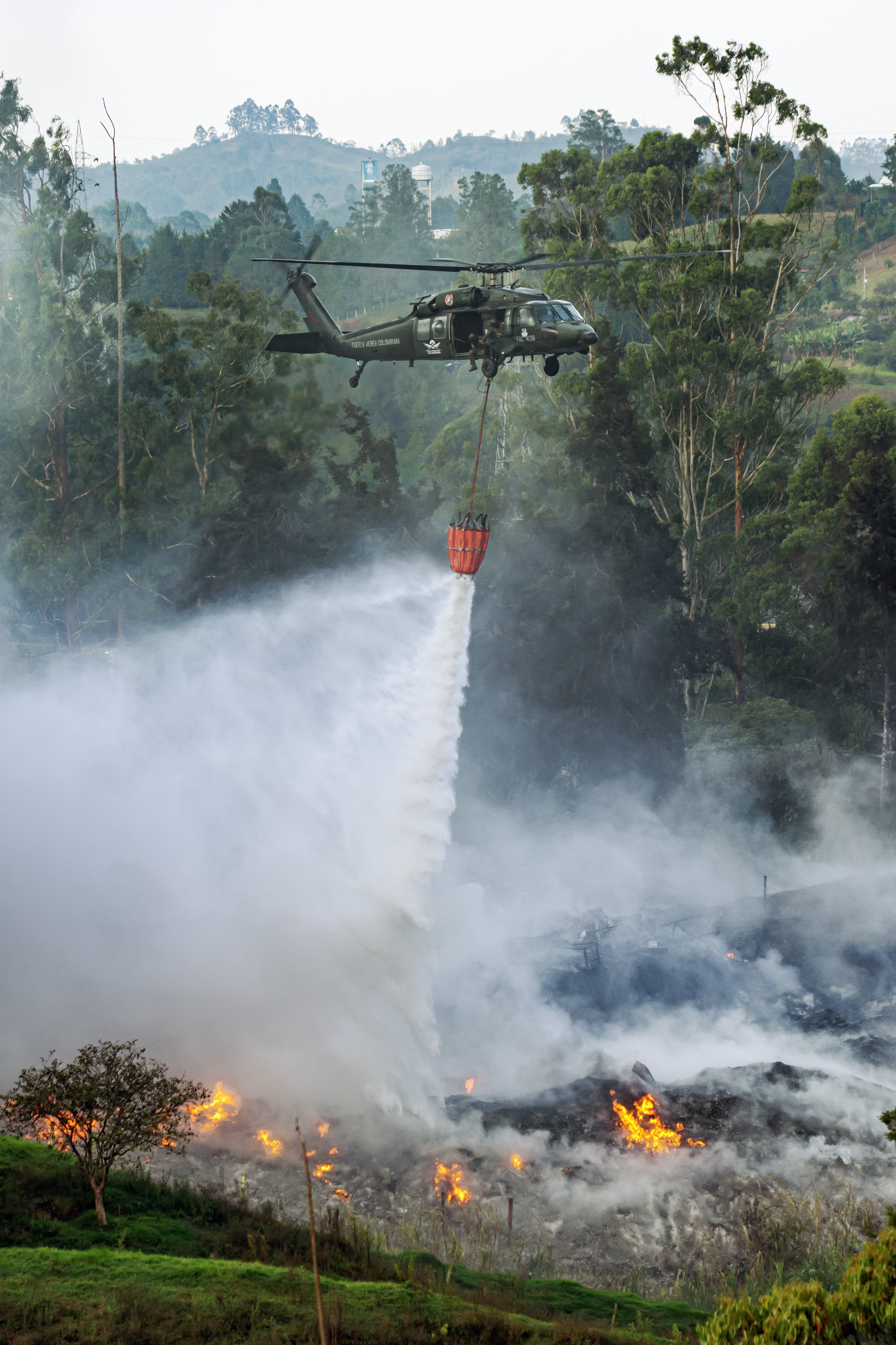 The Colombian Air Force’s "Ángel" helicopter carries out arduous work amidst mountains and tall trees, supporting firefighting operations in the city of Rionegro, Antioquia, Colombia.
