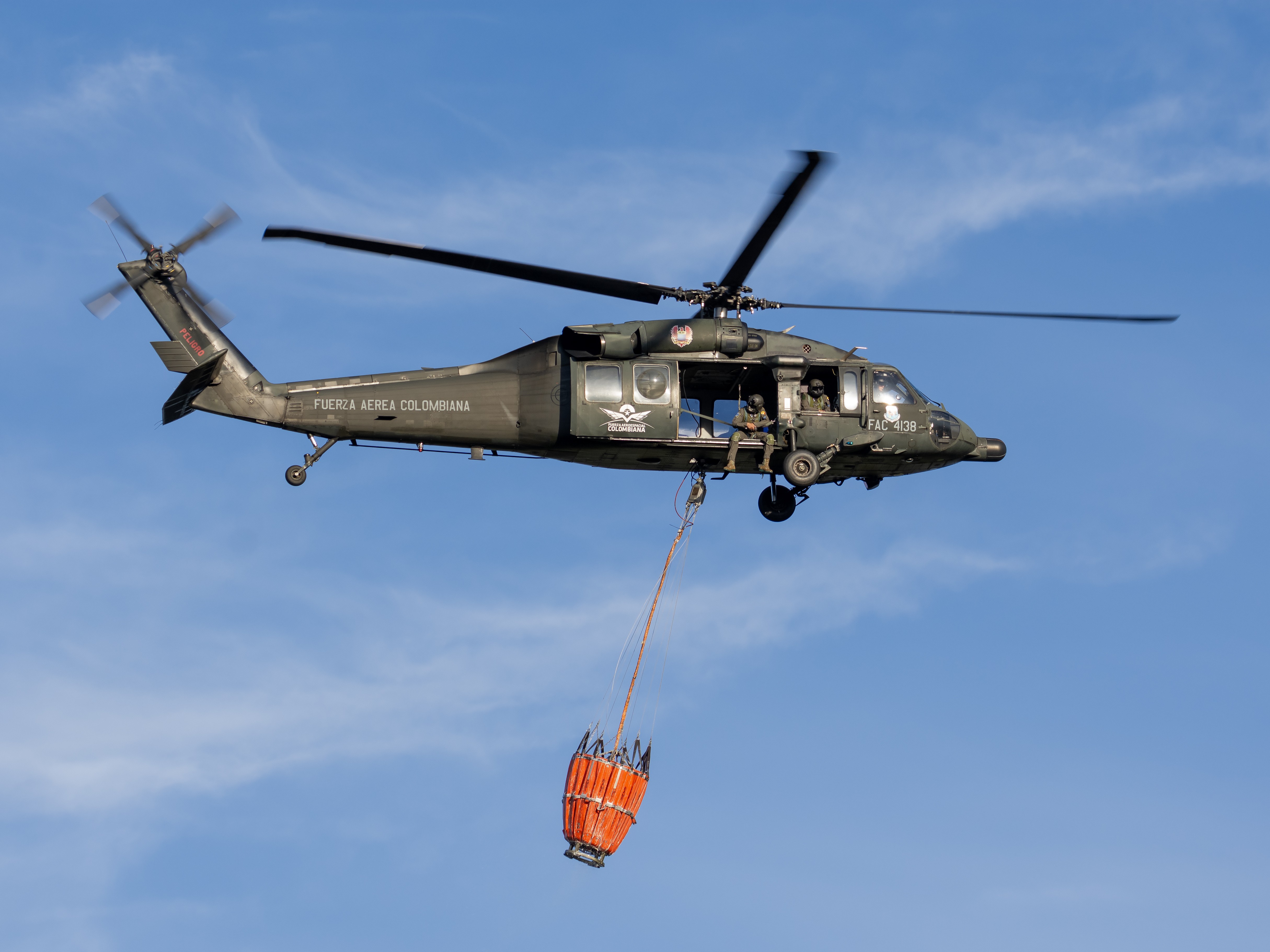 The crew of this Colombian Air Force "Angel" helicopter is conducting an operation that requires coordination between flight, external load handling, and highly precise unloading.