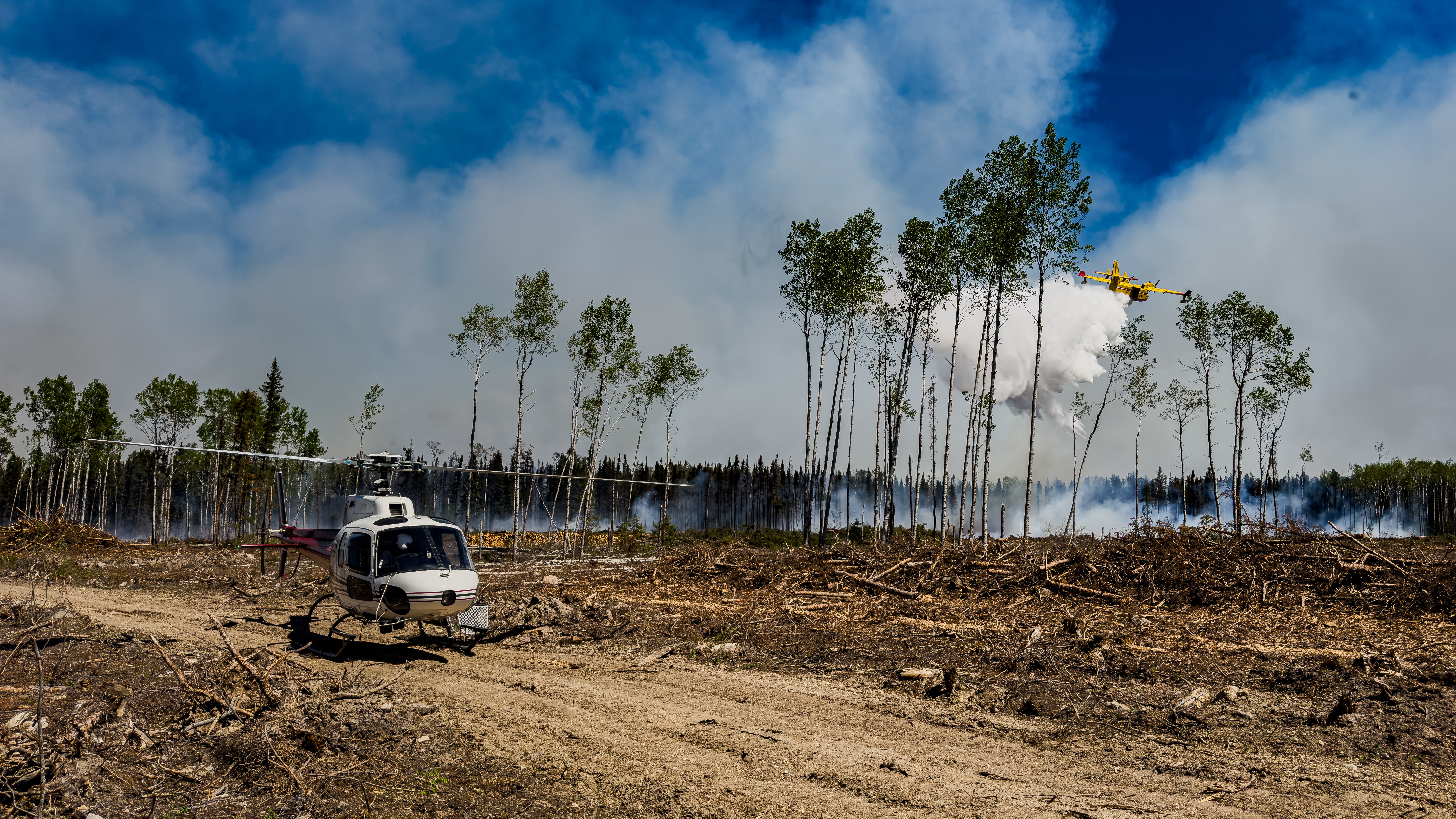 Astar waiting for approval from air attack officer. CL-415 dropping water ahead of dozers as they push guard around out of control fire. Northern Canada.