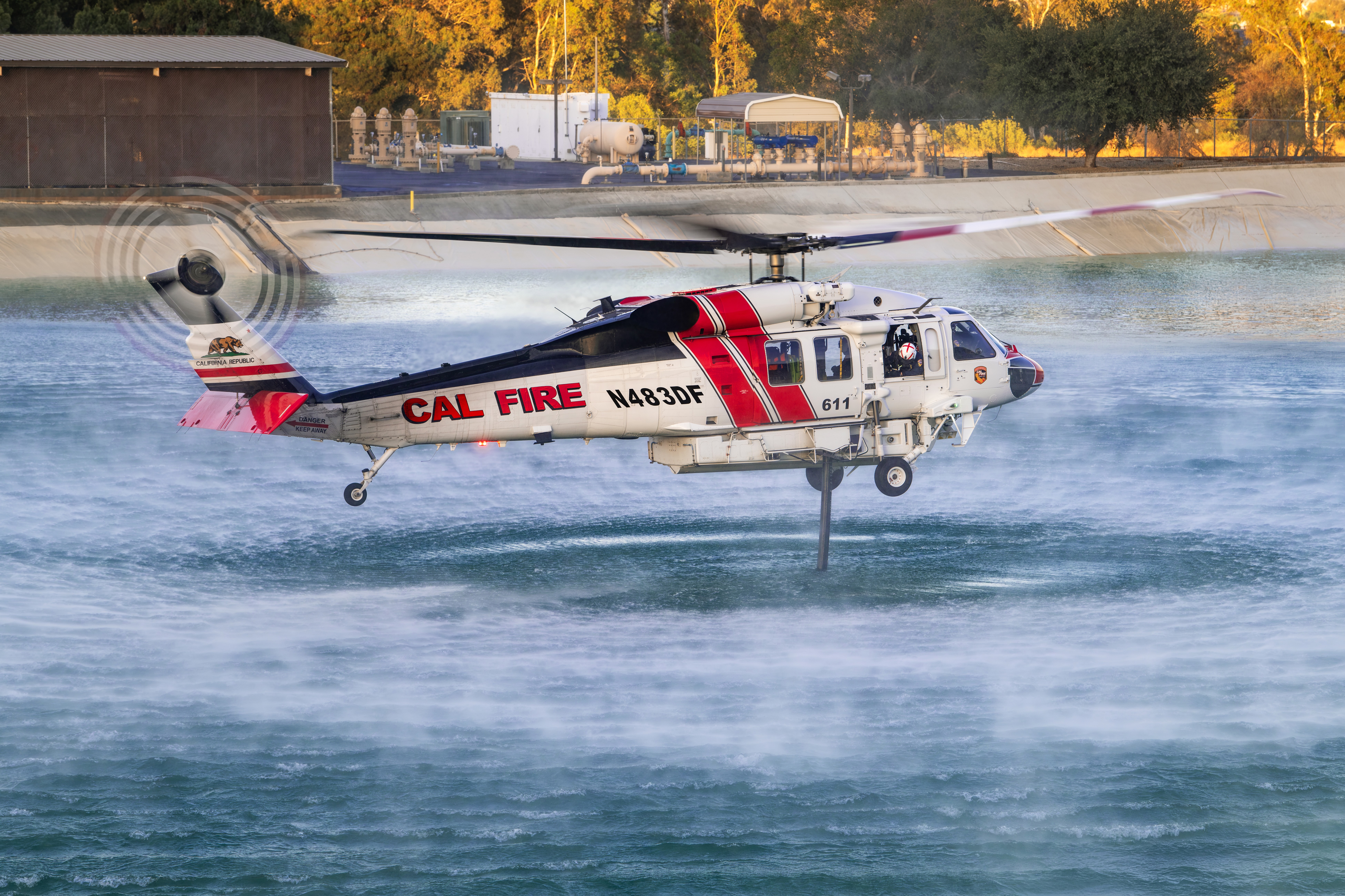 Cal Fire's Firehawk picks up water at a reservoir near Murrieta, California to drop on the Volcano Fire. We parked at the end of a dirt road and then hiked a small mountain to shoot down at the Firehawk.  The sun had just dropped below a small mountain and I liked the soft light illuminating the helicopter.