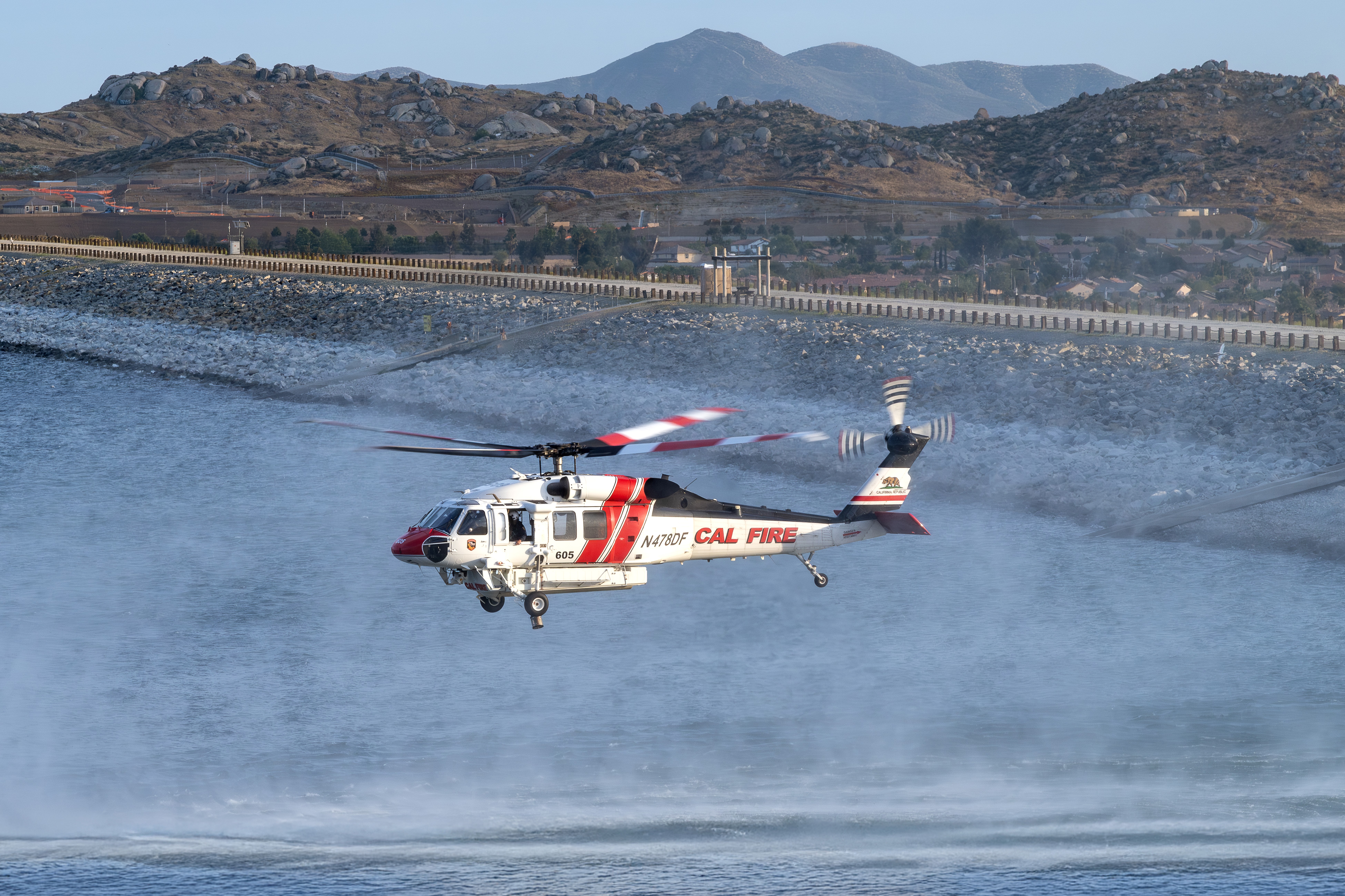 The light and background were so nice, so I decided to do a wider-angle photograph of Cal Fire's Firehawk getting ready to pick up water in Lake Perris, California for the Spring Fire. I climbed up a small hill so I could be at eye level with the helicopters.