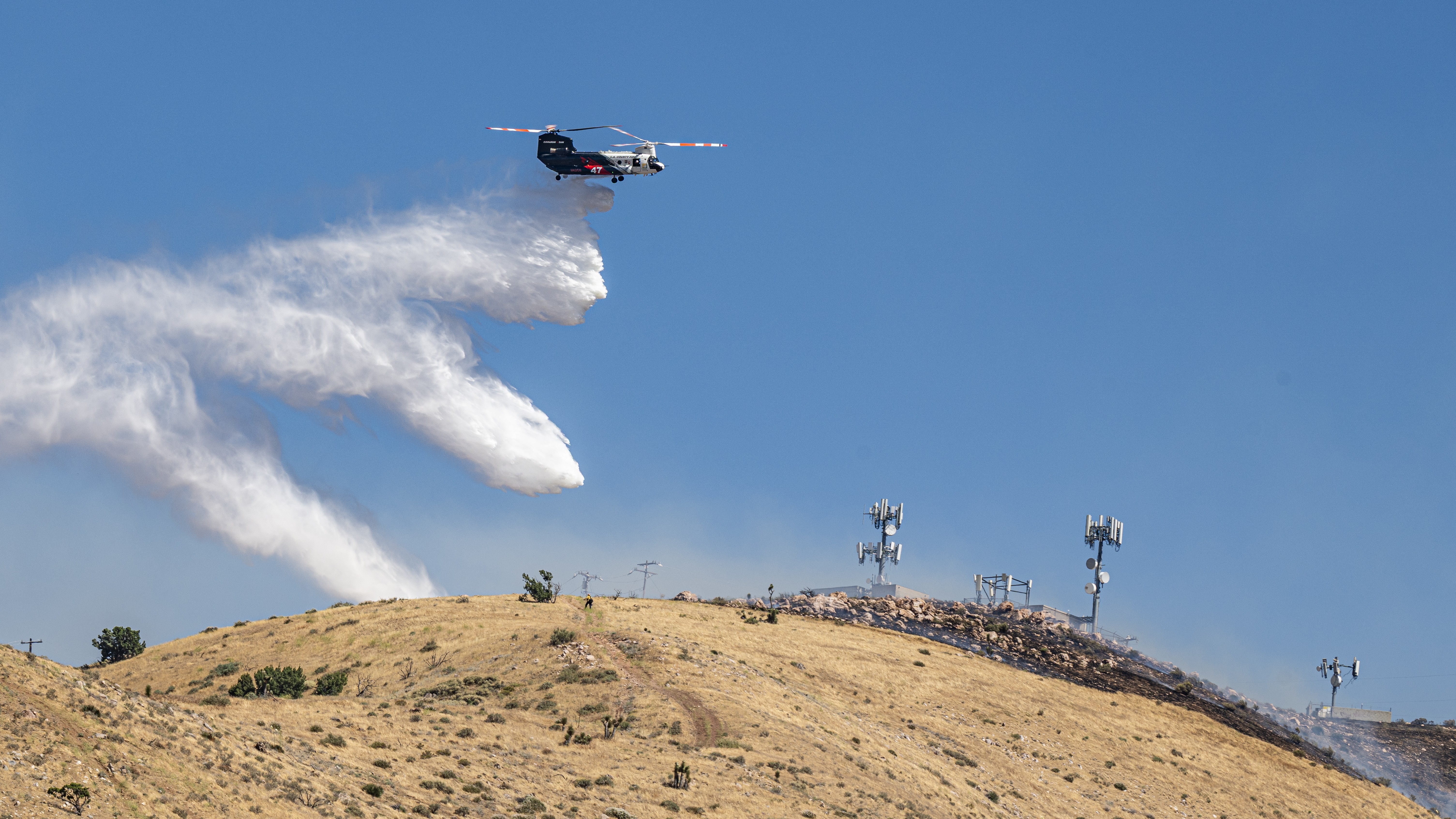 Coulson Aviation's Helitanker 47 makes a water drop to protect important infrastructure in Palmdale, California on the Lemon Incident on June 13, 2026