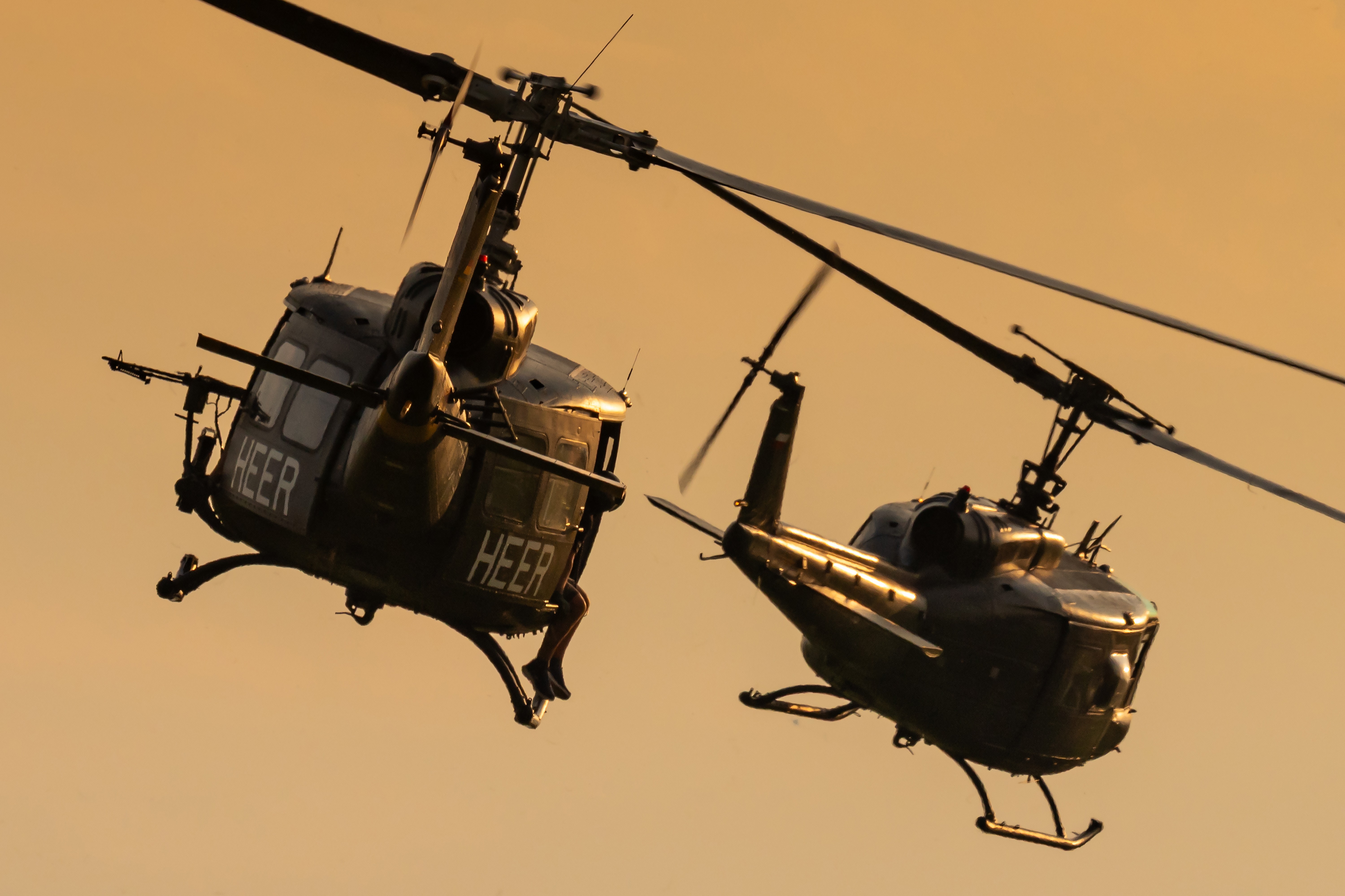 Two Bell UH-1 Iroquois military transport helicopters from Germany performing a Vietnam demo during a beautiful sunset at the Antidotum airshow in Leszno, Poland.