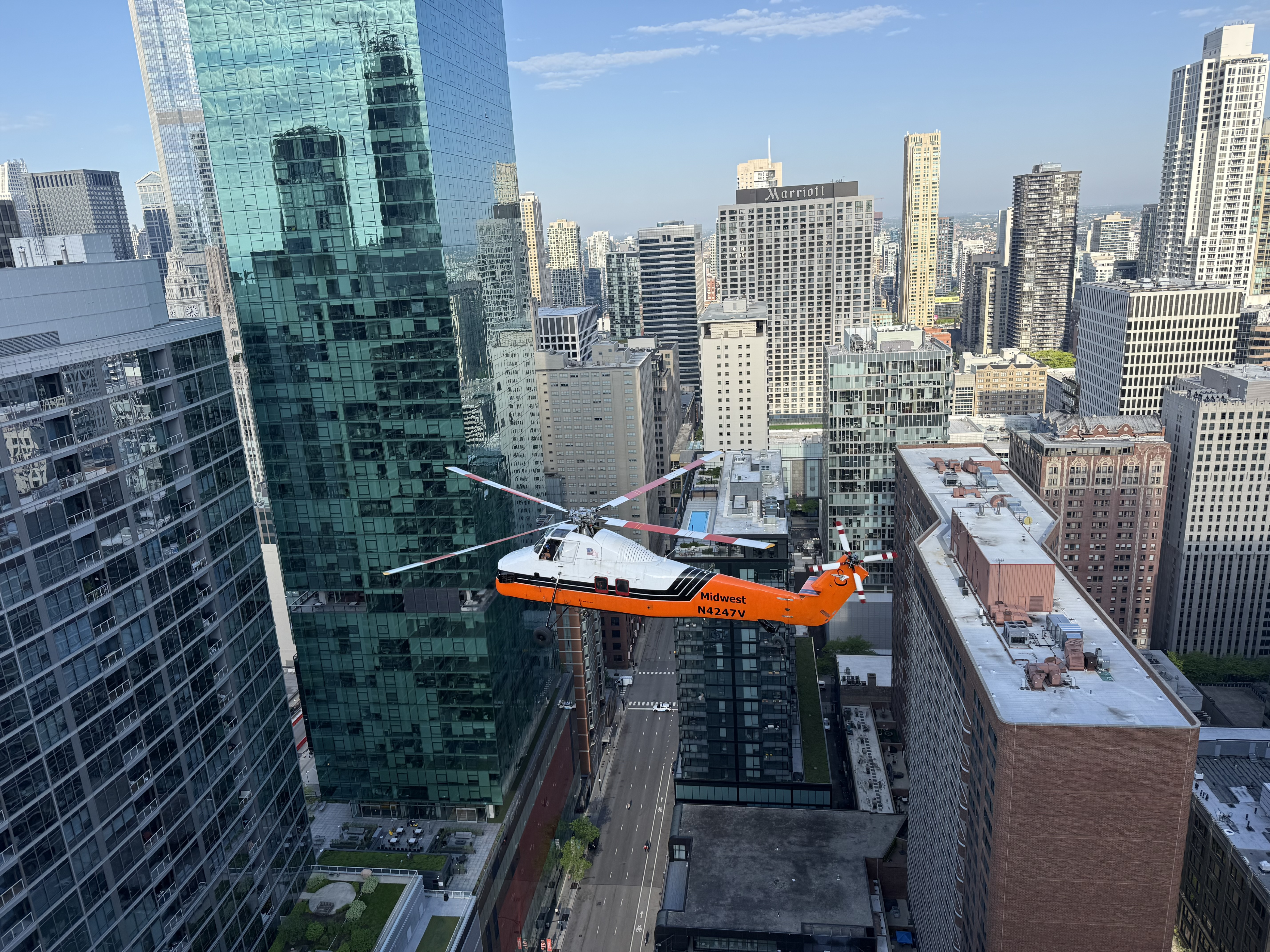 Midwest Helicopter Airways’ Sikorsky S-58T maneuvers between the skyscrapers of downtown Chicago during an aerial lift operation. Captured from a nearby rooftop, the photo offers a unique perspective of the aircraft working within the city skyline, where tight spaces and limited ground access make helicopter lifting an ideal solution. Precision flying, careful coordination, and an incredible view come together high above the streets of Chicago.