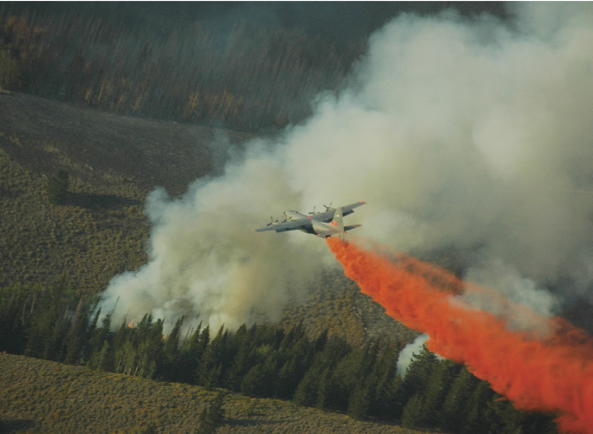 A C-130 uses aerial firefighting equipment known as the Modular Airborne Fire Fighting System to drop red-colored retardant, or ‘slurry’ as it is sometimes called, from the plane into the air over a fire. MAFFS was established by Congress in the early 1970s to create a national response system to better fight major fires. (U.S. Air Force Photo)