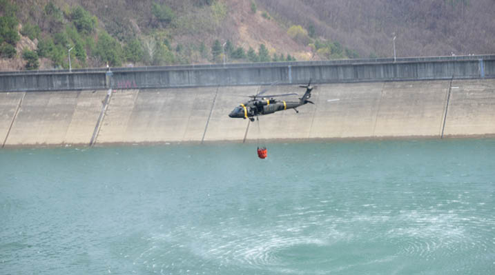 U.S. Forces Korea is assisting efforts to contain wildfires in southeastern regions of the Republic of Korea. In coordination with the ROK Joint Chiefs of Staff and Combined Forces Command, USFK has deployed UH-60 Black Hawk helicopters equipped with Bambi Buckets to support aerial water drop operations. Personnel from the 2nd Combat Aviation Brigade, including pilots and crew chiefs, are actively supporting the mission, with additional assets on standby if needed. (U.S. Army photo by Sgt. Alexander Knight)
