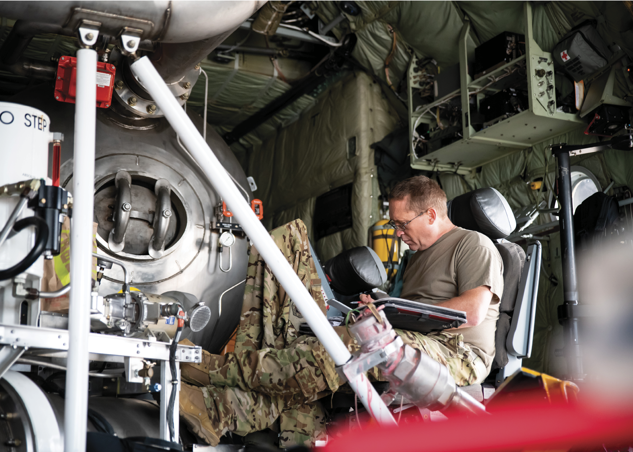 Staff Sergeant Christian Linde, Crew Chief for the 153d Airlift Wing, prepares paperwork on a C-130 Hercules aircraft equipped with a U.S. Forest Service Modular Airborne Fire Fighting System (MAFFS) in Cheyenne, Wyo. on August 3, 2023. The Wyoming Air National Guard MAFFS unit is activated to support the western area wildfires. (U.S. Air National Guard photo by Senior Airman Kylee Warren)