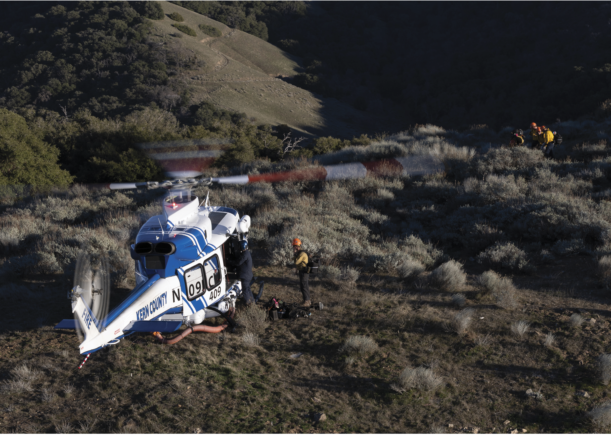 A helicopter is on the ground in a field, with a person standing next to it. AI generated content