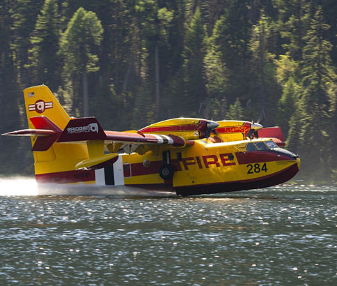 A yellow and red airplane with the number 242 on it is flying over a body of water. AI generated content