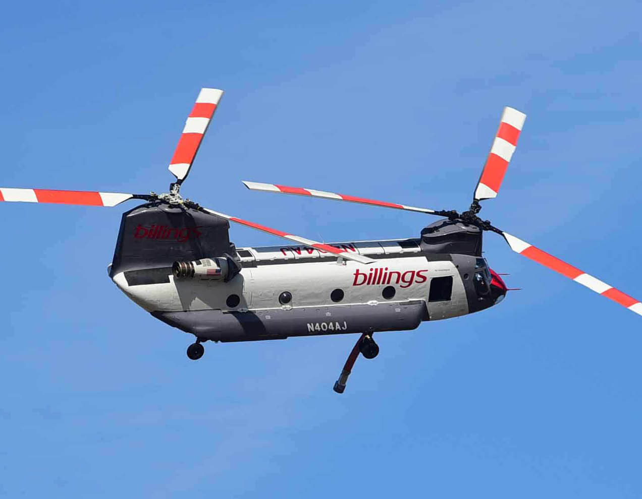 A helicopter with a red and white tail flies in the sky. AI generated content