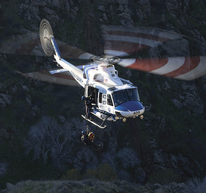 A helicopter is flying over a mountain with a person hanging from a rope. AI generated content