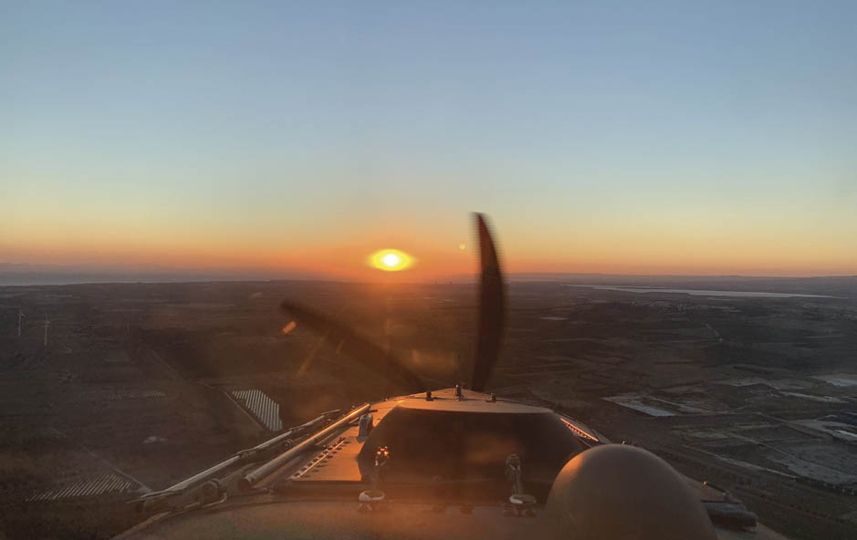 A plane's propeller is visible in the foreground, with a beautiful sunset in the background. AI generated content
