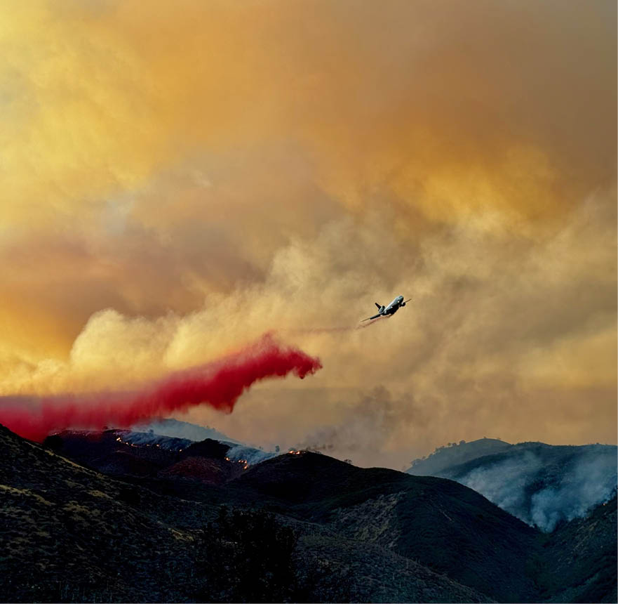 A plane is flying over a mountain range with a red trail behind it. AI generated content