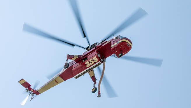 A red helicopter with a number 32 on it is flying in the air. AI generated content