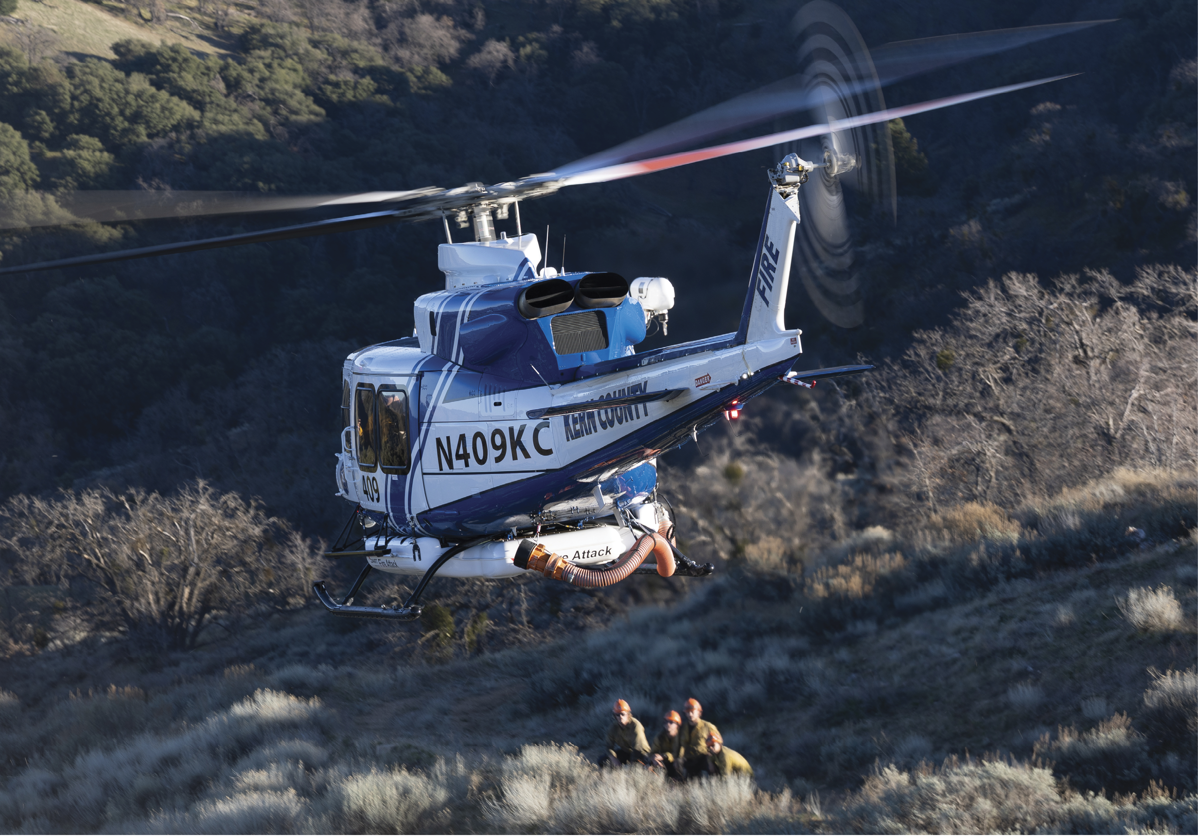 A helicopter is flying over a mountain with a person on the ground. AI generated content