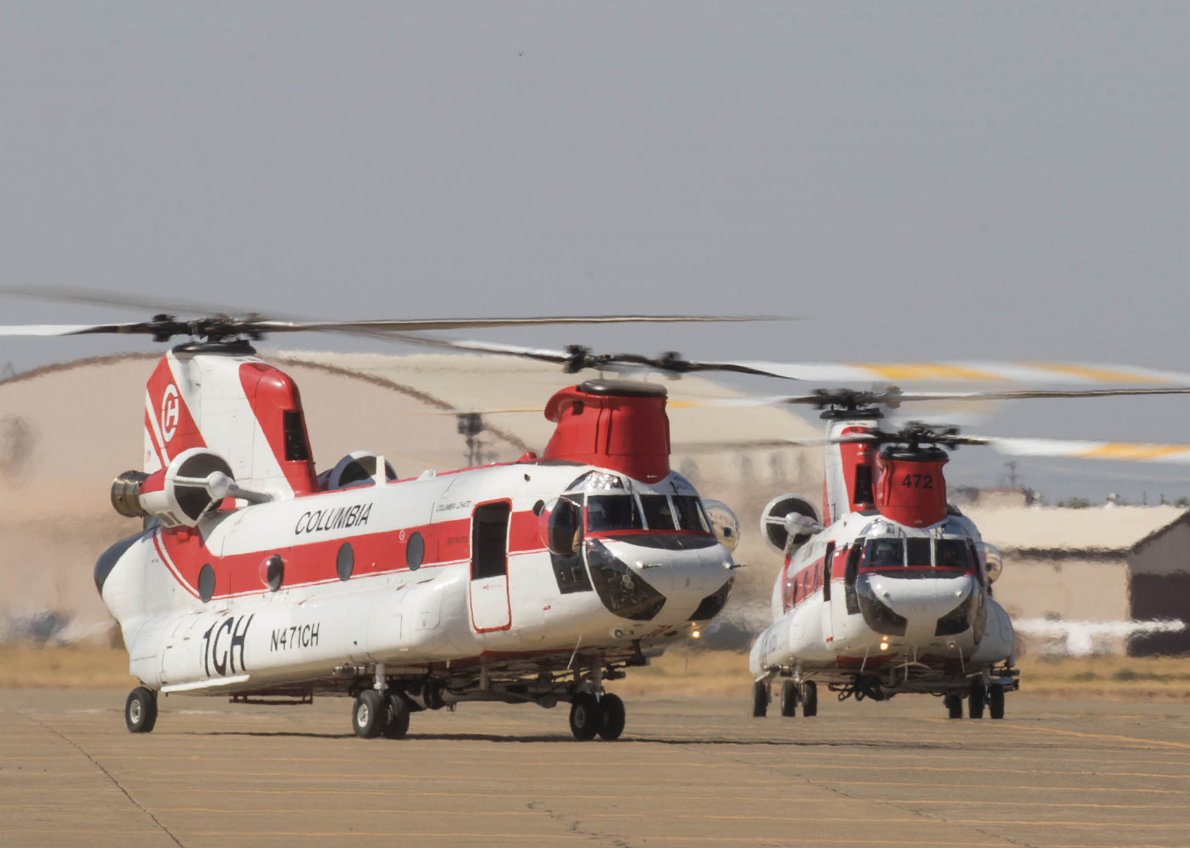 Two red and white helicopters are on a runway, one is flying and the other is on the ground. AI generated content