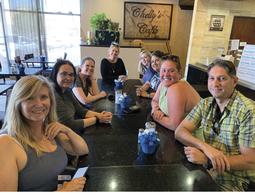 A group of people are sitting around a table in a restaurant. AI generated content