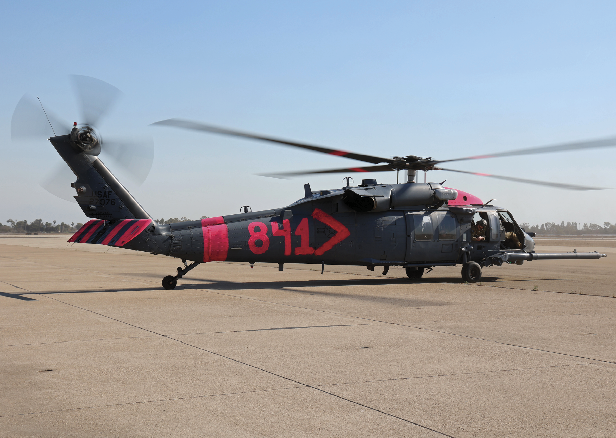 A helicopter with the number 814 on it is parked on a runway. AI generated content
