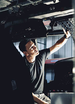 A man is working on an airplane, looking at the control panel. AI generated content