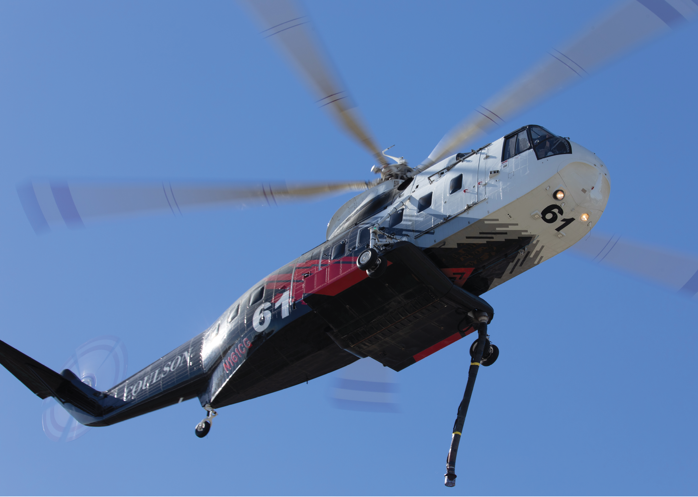 A helicopter with a red and black paint job is flying in the sky. AI generated content