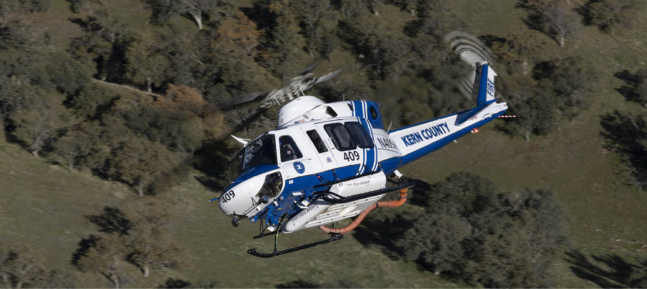 A blue and white helicopter is flying over a grassy field. AI generated content