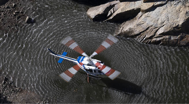 A helicopter is floating on the water, with its propeller spinning. AI generated content