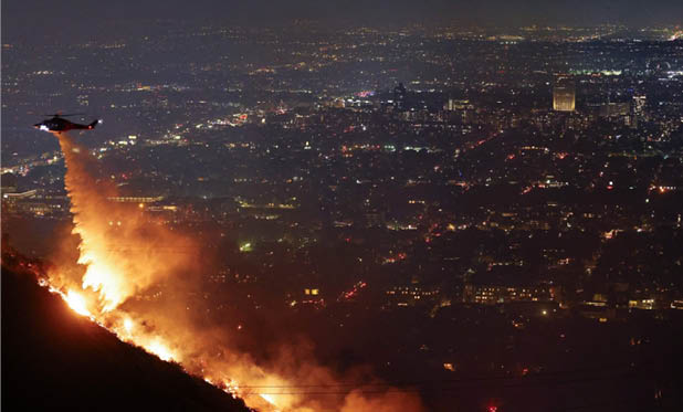 A helicopter is flying over a city at night, with a fire visible in the distance. AI generated content