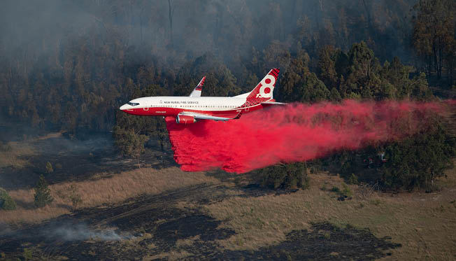 A red and white airplane is flying through a field with smoke trailing behind it. AI generated content