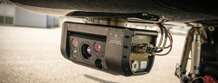 A camera is mounted on the bottom of a vehicle, with a red light on. AI generated content