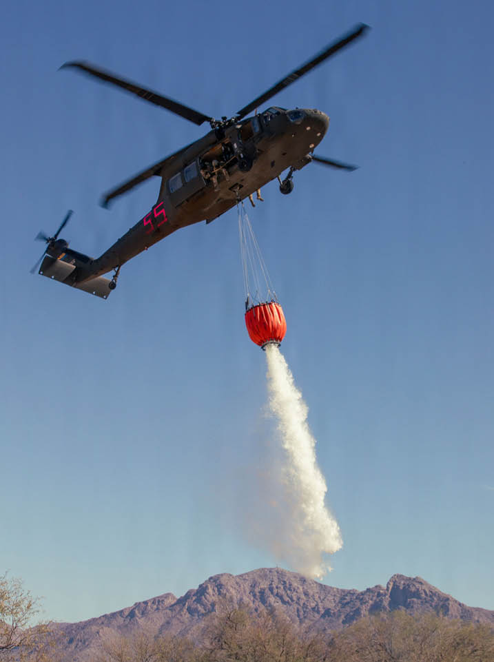 A helicopter is flying over a mountain range, dropping a red object. AI generated content