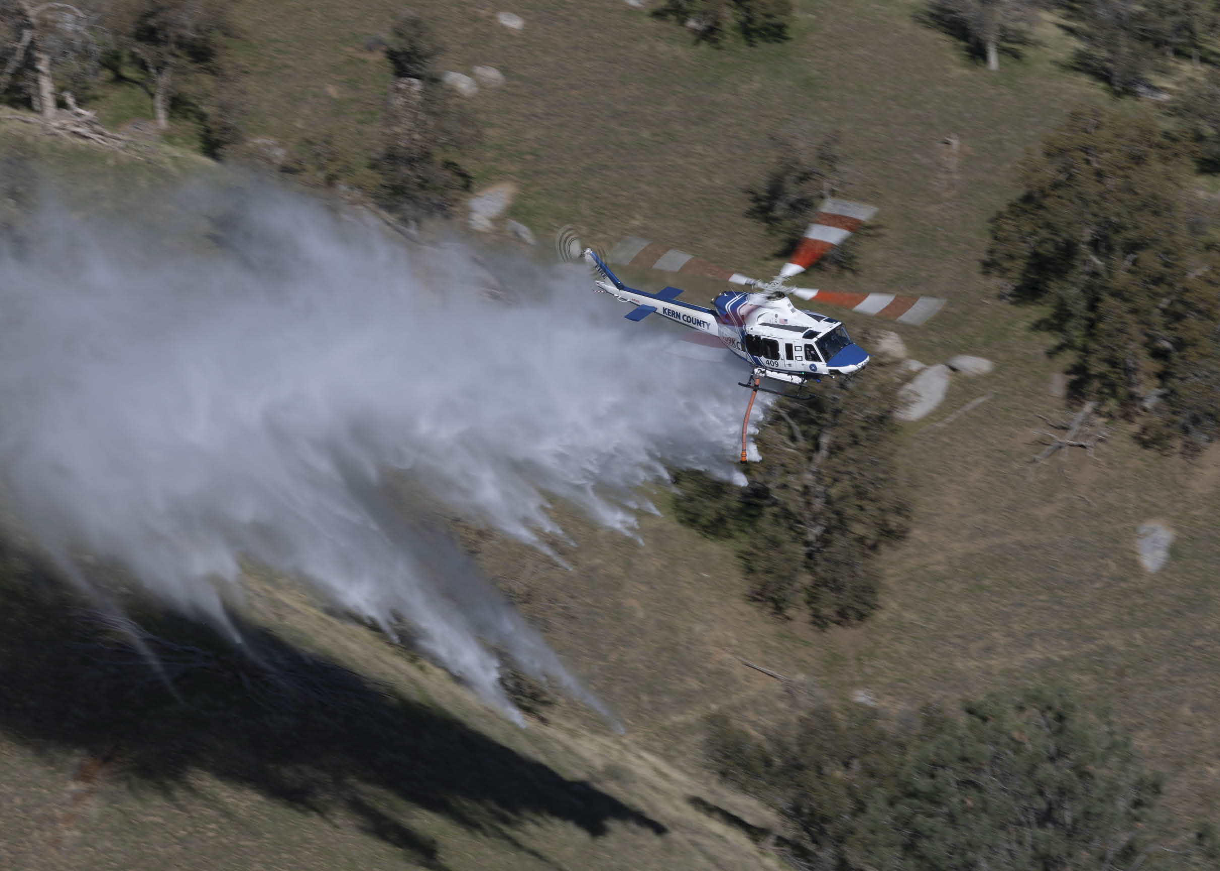 A helicopter is spraying water on a field. AI generated content