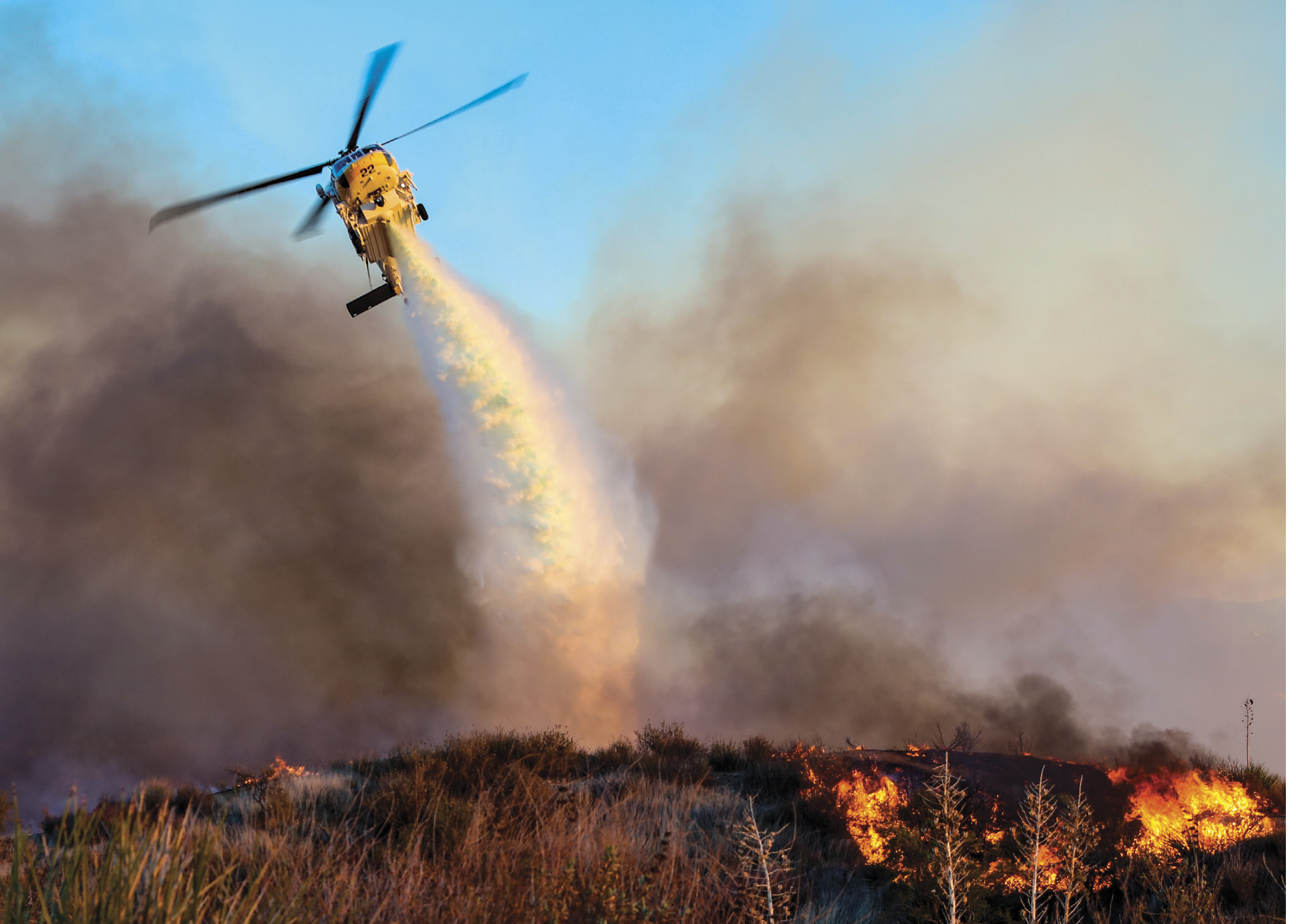 A helicopter is flying over a forest, spraying water to put out a fire. AI generated content