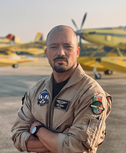 A man in a tan jacket stands in front of a yellow airplane. AI generated content
