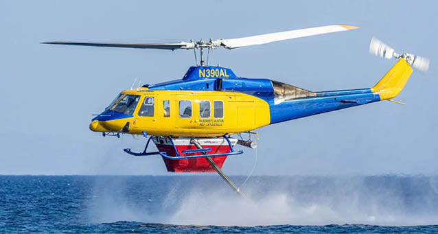 A yellow and blue helicopter is flying over the water, creating a spray of water as it flies. AI generated content