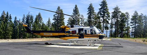 A yellow and black helicopter is parked on a runway. AI generated content