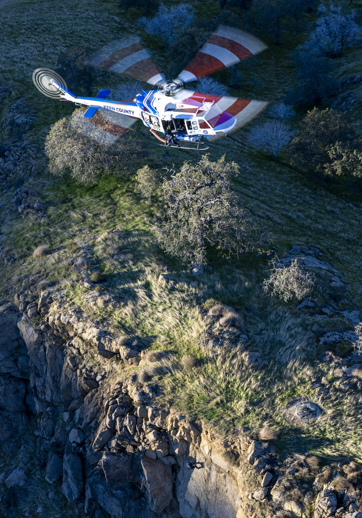 A helicopter is flying over a rocky hillside. AI generated content