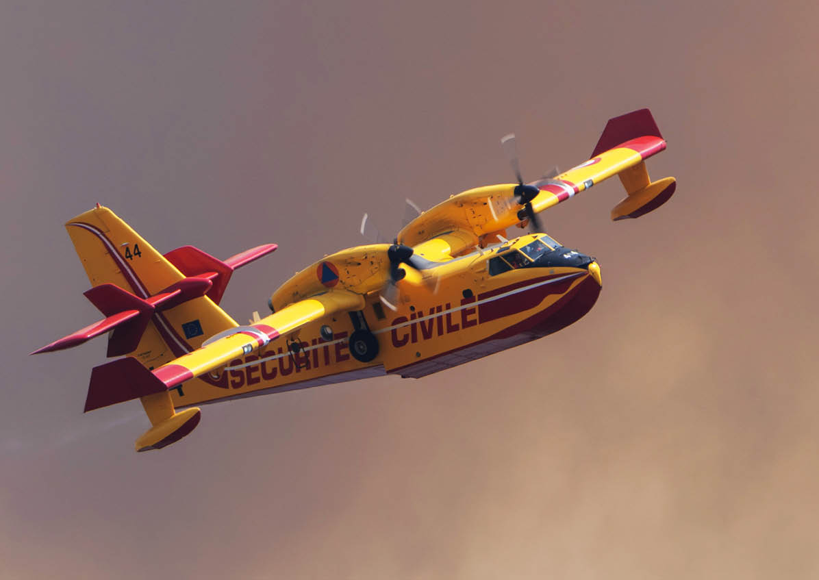 A yellow and red firefighting airplane with the words “Securite Civile" is flying against a smoky sky. Description generated by AI