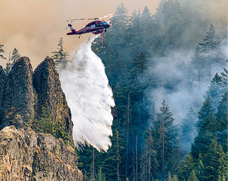 A helicopter is flying over a city at night, with a fire visible in the distance. AI generated content