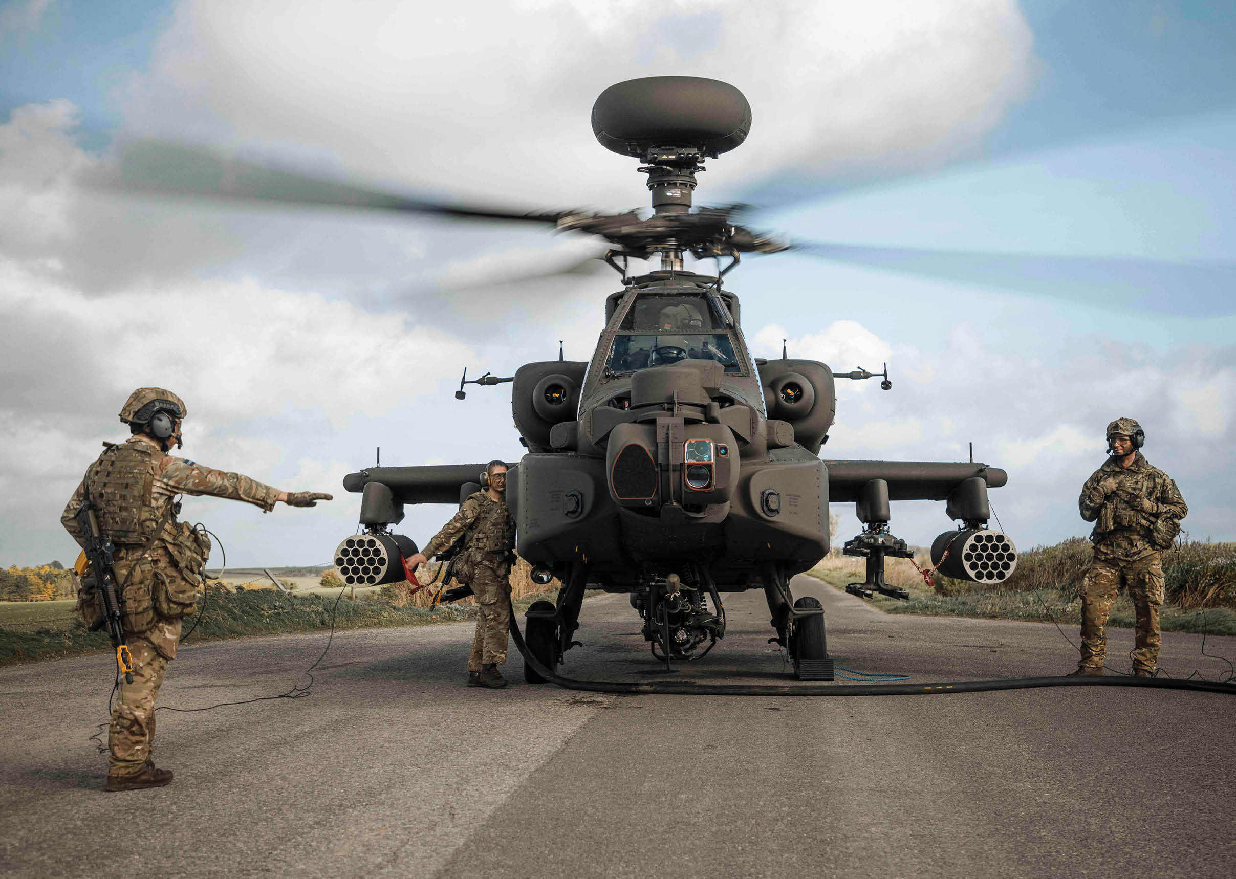 A member of 3 Regt Army Air Corps refuels an Apache AH64-E. The British Army’s new Apache AH-64E attack helicopter has taken its first outing into the field.  Exercise Talon Guardian has seen 3 Regiment Army Air Corps operate its AH-64Es from three separate locations on a two-week-long, 1,500km journey across the country.  Engineers have been keeping the aircraft in working order in the field, while aircrew have been planning and executing strike missions, supported by groundcrew running Forward Arming and Refuelling Points to keep the AH-64E’s fuel tanks and weapons pylons full.  3 Regt AAC is the first unit to field the AH-64E, which brings improved flying performance, sensors, weapons, and communications systems over the Apache Mk.1 it replaces.  The training is to rehearse 3 Regt AAC in its role to provide an aviation deep strike battlegroup to 3rd (UK) Division, the British Army’s war fighting division.