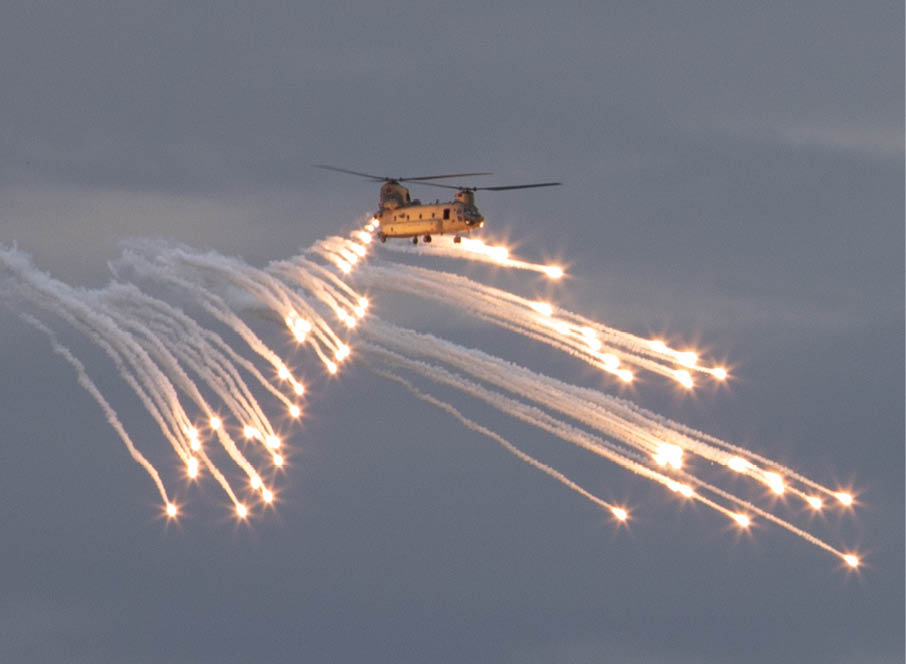 A CH-47 Chinook helicopter, operated by Soldiers assigned to the 1st Combat Aviation Brigade, fires flares on Grafenwoehr Training Area, Germany, Aug. 4, 2021. Soldiers assigned to 1st CAB from Fort Riley are currently on rotation in Germany to prepare for Saber Junction 2021. (U.S. Army Photo by Pfc. Jacob Bradford)