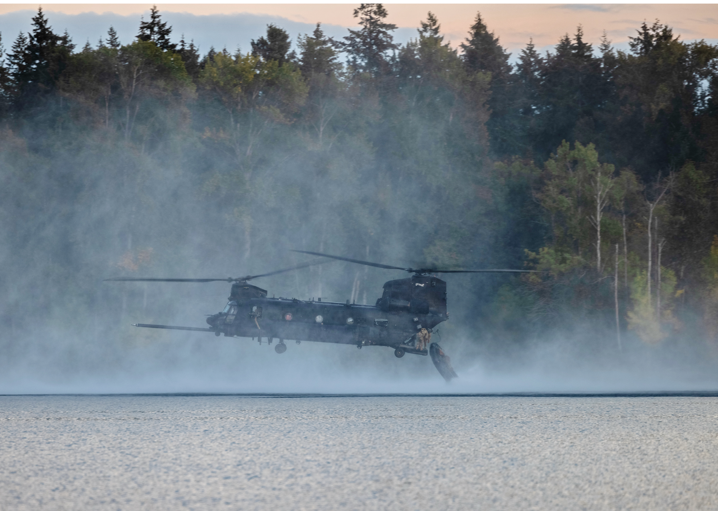 U.S. Marines with Charlie Company, 1st Reconnaissance Battalion, 1st Marine Division, push a combat rubber raiding craft out the back of a U.S. Army MH-47 Chinook helicopter as part of a combat readiness evaluation at Joint Base Lewis-McChord, Washington, Oct. 9, 2024. The combat readiness evaluation is a form al test based on mission essential tasks that evaluates the combat readiness of Marine units. (U.S. Marine Corps photo by Cpl. Jaye Townsend)