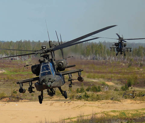A U.S. AH-64 Apache fires missiles at targets during a training mission at Camp da i, Latvia, May 02, 2025. Four AH-64 Apaches from the Combat Aviation Brigade, 1st Armored Division,  flew to a training area at Camp Adazi to demonstrate the aircraft’s precision and lethality to distinguished guests attending the training event. The U.S. remains committed to the NATO alliance and our Latvian allies. Latvia’s investment in its defense and cooperation with the U.S. strengthens deterrence and security along NATO’s eastern flank. (U.S. Army photo by Staff Sgt. Rose Di Trolio)