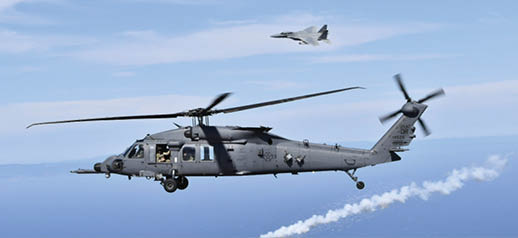 U.S. Air Force HH-60W Jolly Green II assigned to the 305th Rescue Squadron, Davis Monthan Air Force Base, Ariz., deploys countermeasure flares as an U.S. Air Force F-15D Eagle from the 144th Fighter Wing, California Air National Guard, maneuvers overhead during a joint over-water test flight, Aug. 20, 2025. (U.S. Air Force courtesy photo)