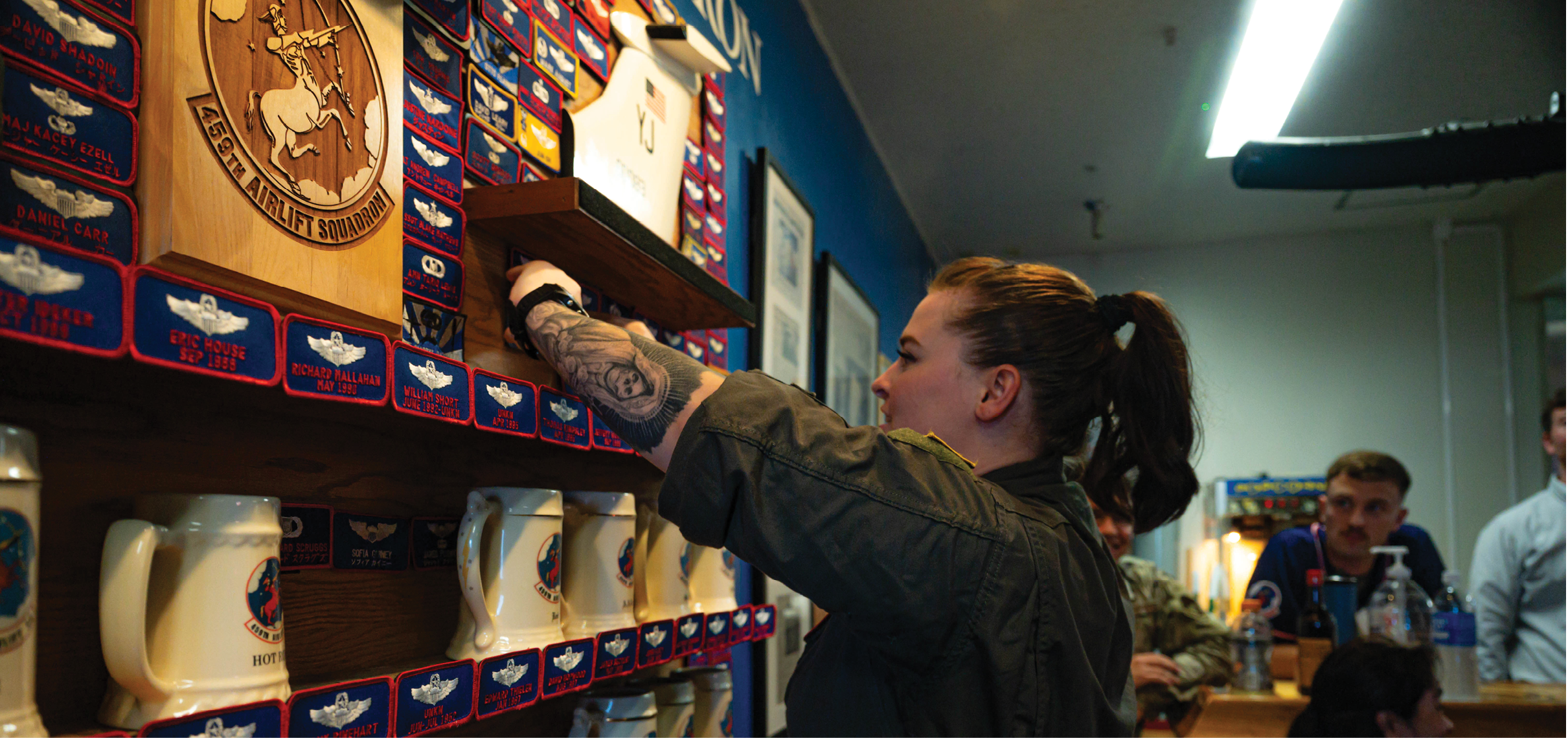 U.S. Air Force Senior Airman Kayli Rodriguez, 459th Airlift Squadron flight engineer, places a nametape on the 459 AS heritage room wall at Yokota Air Base, Japan, Aug 29, 2025. After more than 40 years of service, the UH-1N retired from Yokota, where it has supported aeromedical evacuation, search and rescue, and priority airlift missions throughout the Indo-Pacific. (U.S. Air Force photo by Staff Sgt. Manuel G. Zamora)
