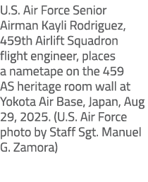 U.S. Air Force Senior Airman Kayli Rodriguez, 459th Airlift Squadron flight engineer, places a nametape on the 459 AS...