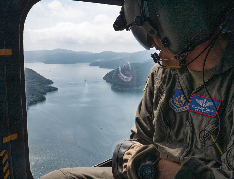 U.S. Air Force Tech. Sgt. Chris Taylor, 459th Airlift Squadron special mission aviator, gazes out of a UH-1N Huey during its final operational flight at Yokota Air Base, Japan, Aug. 29, 2025. The UH-1N Huey has maintained a presence at Yokota for 45 years, providing aeromedical evacuation, search and rescue and priority airlift missions throughout the Pacific. (U.S. Air Force photo by Senior Airman Jacob Wood)