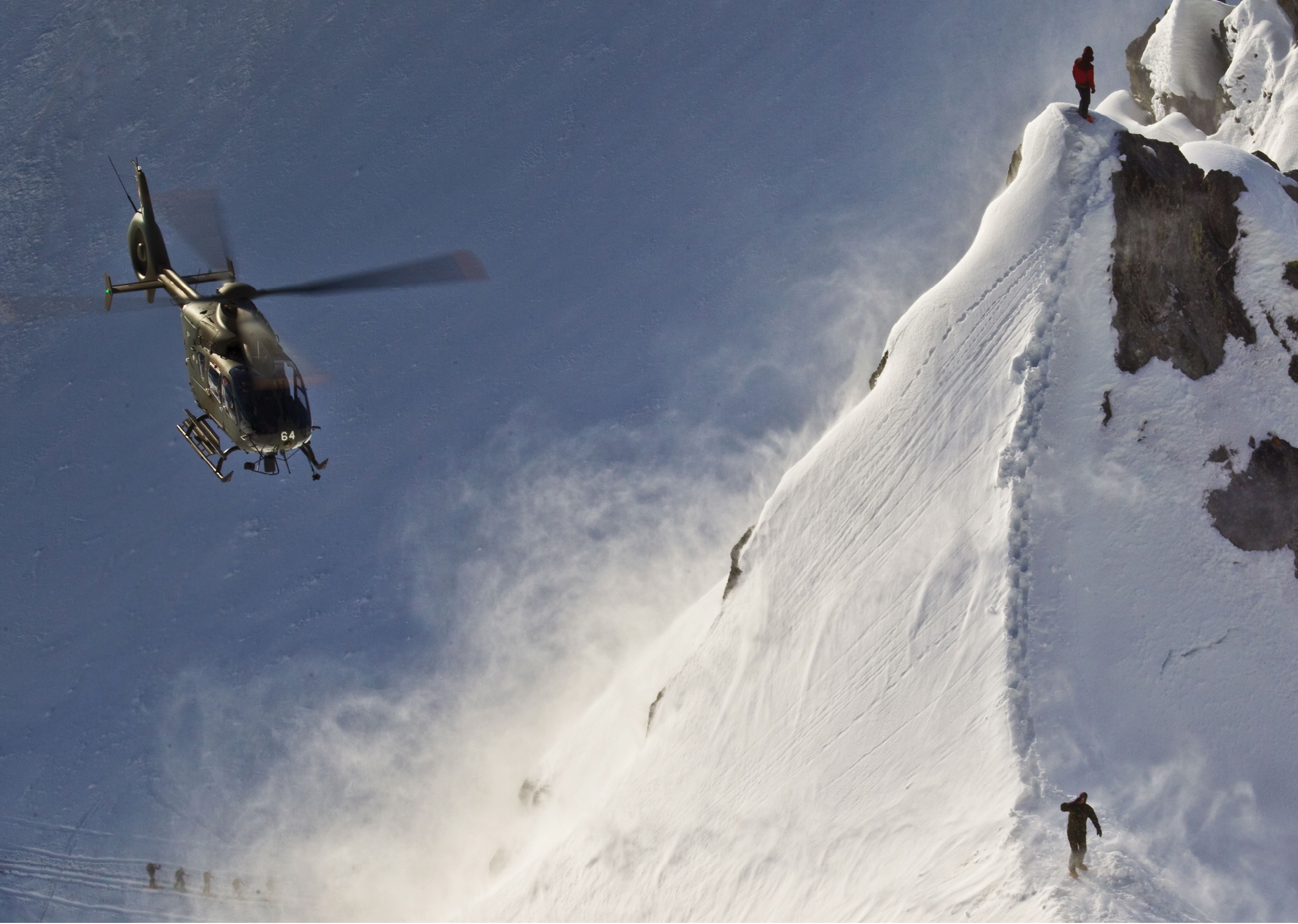 A helicopter is flying over a snowy mountain with a person on the side. AI generated content