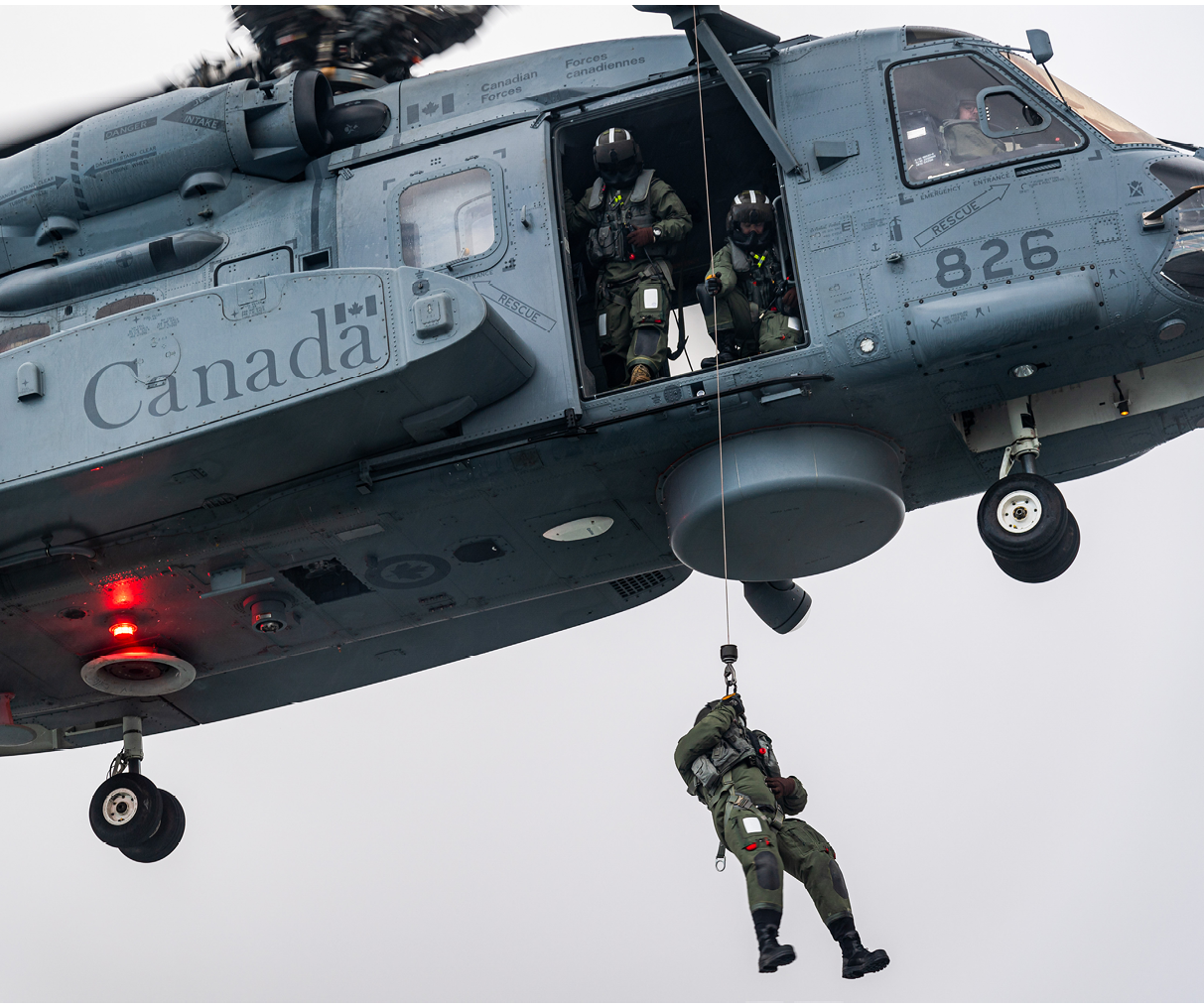 A man is hanging from a helicopter, wearing a green outfit. AI generated content