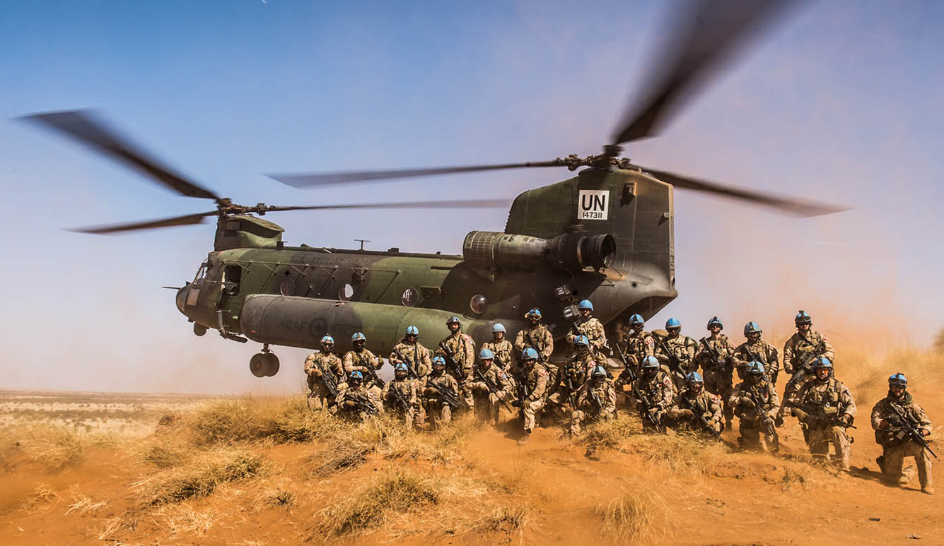 A group of soldiers are standing in the dirt, with a helicopter flying above them. AI generated content