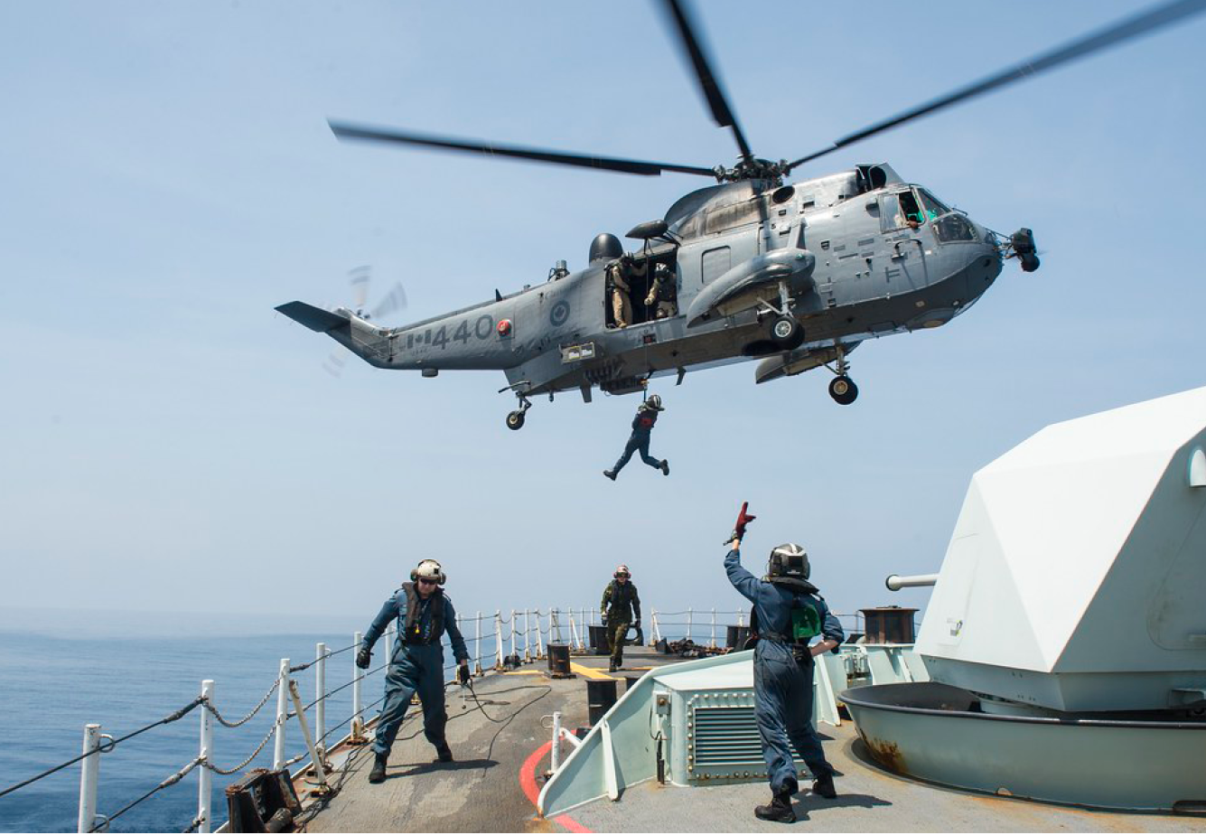 A helicopter is flying over a boat with a person hanging from a rope. AI generated content